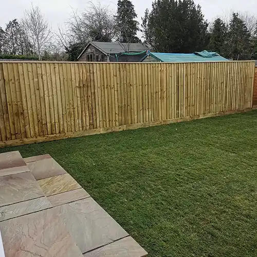 a backyard with a wooden fence and grass